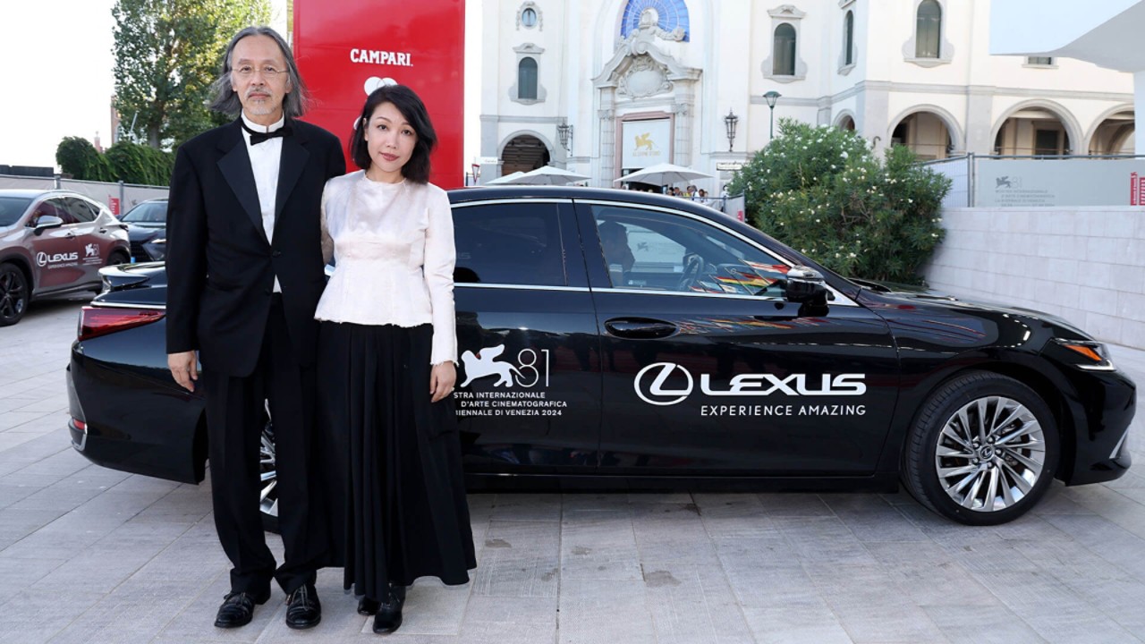 acob Wong and Zhang Xiaowen stood by a Lexus at the 81st Venice film festival